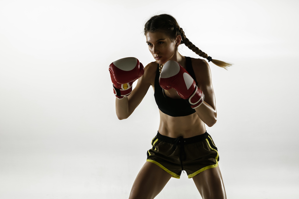 Woman practicing fitness boxing wearing boxing gloves